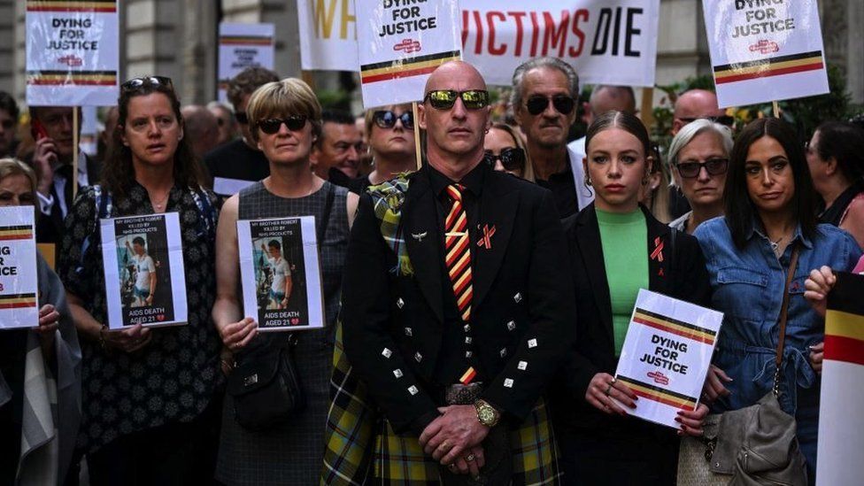 Protesters holding placards with messages related to the NHS infected blood scandal