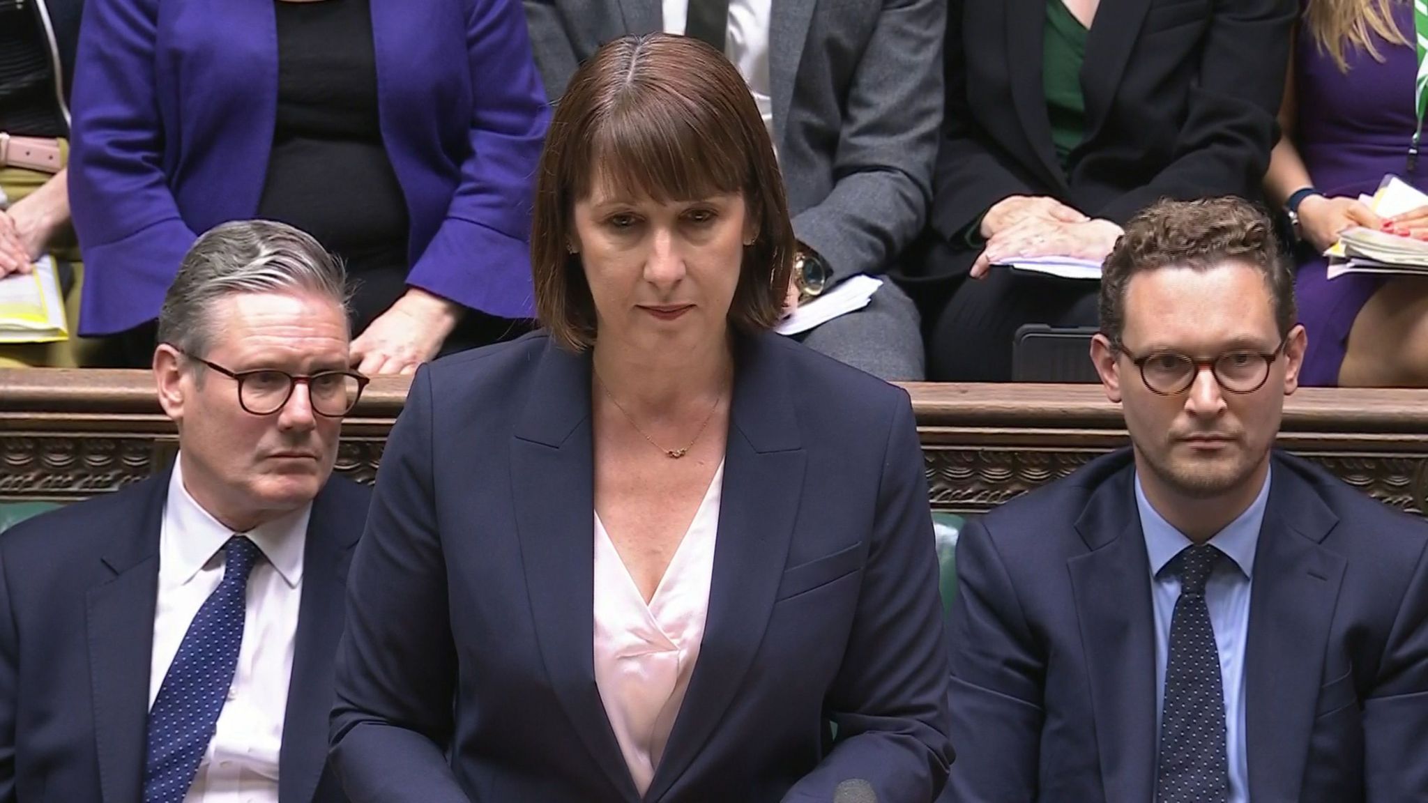 Rachel Reeves looking solemn, standing at the box in the House of Commons with Sir Keir Starmer next to her