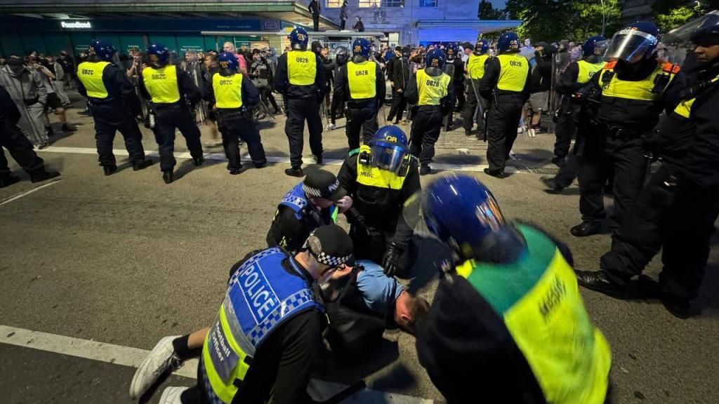 Police officers detain individuals in Plymouth after they tried crossing into the anti-racism counter protest they tried crossing into the counter protest