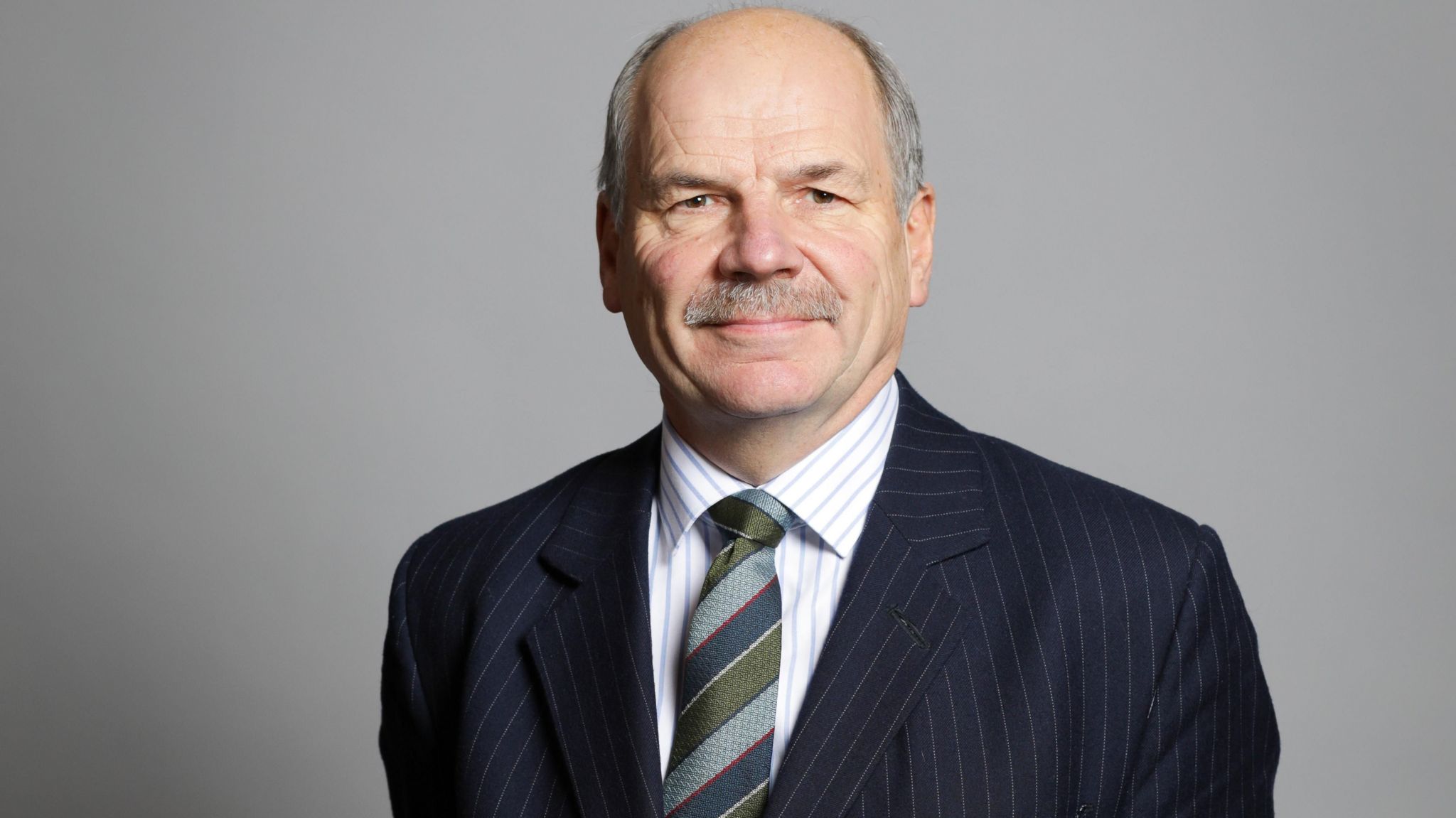 Earl Attlee wearing a suit and tie for his official House of Lords portrait in 2019.