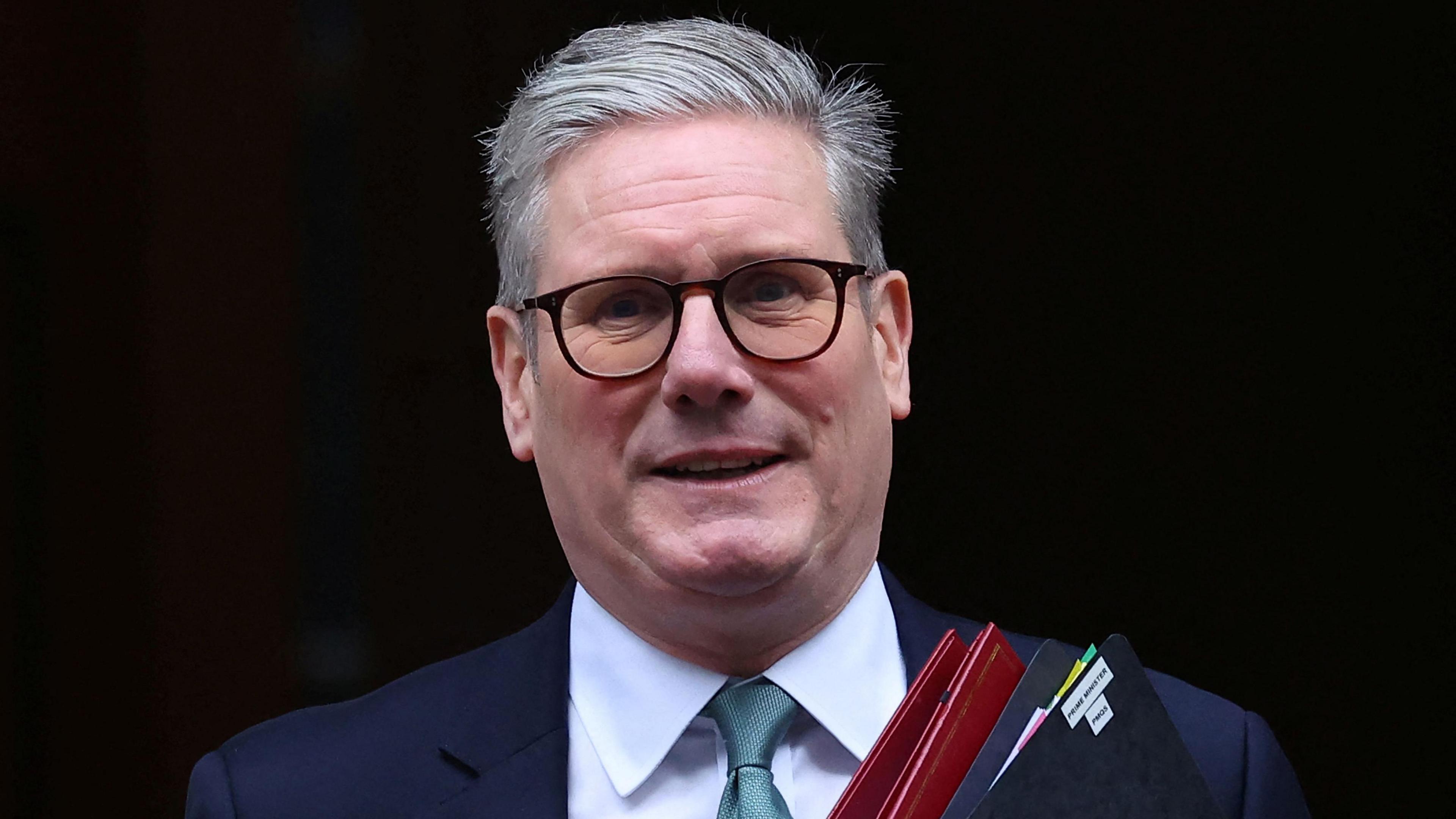 Prime Minister Sir Keir Starmer leaving Downing Street holding red and black folders