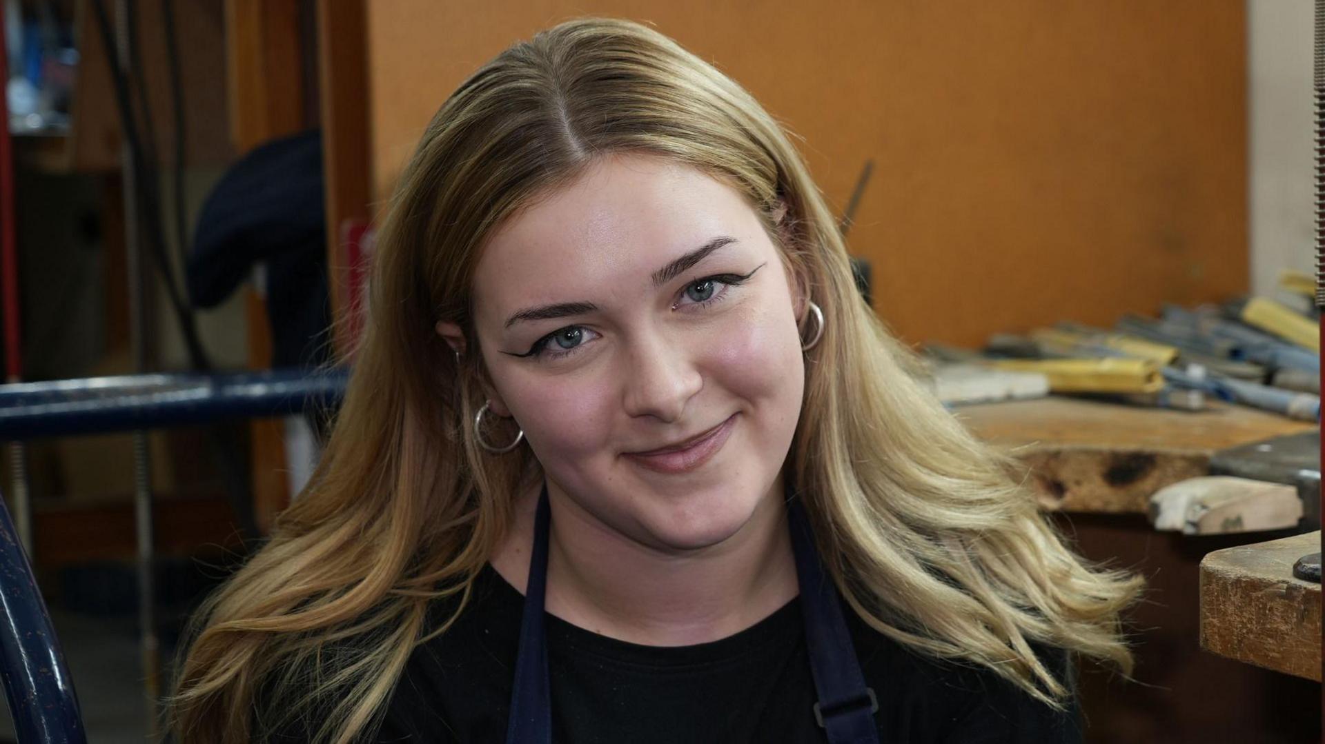 Apprentice Abi sits and smiles at the camera