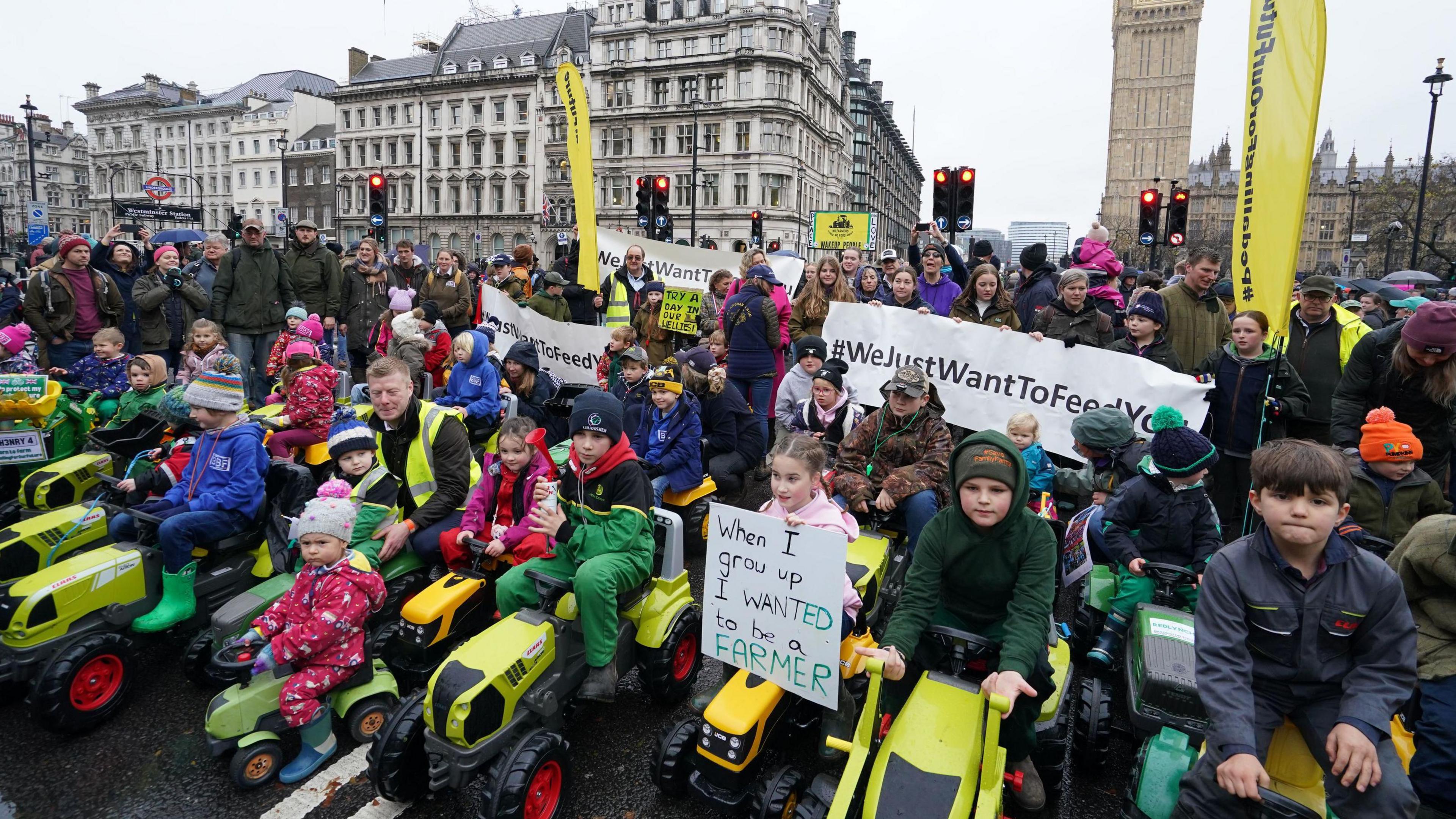 Dozens of children sit on toy tractors in central London, at the protest