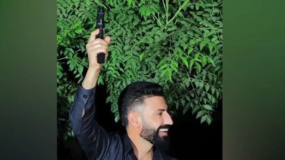 Amanj Hasan Zada, a jailed people smuggler, firing a gun in celebration at a party. 