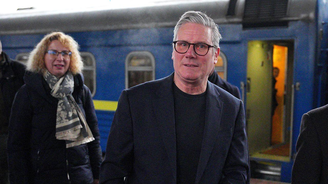 Sir Keir Starmer steps off the train at Kyiv railway station with a person in the background