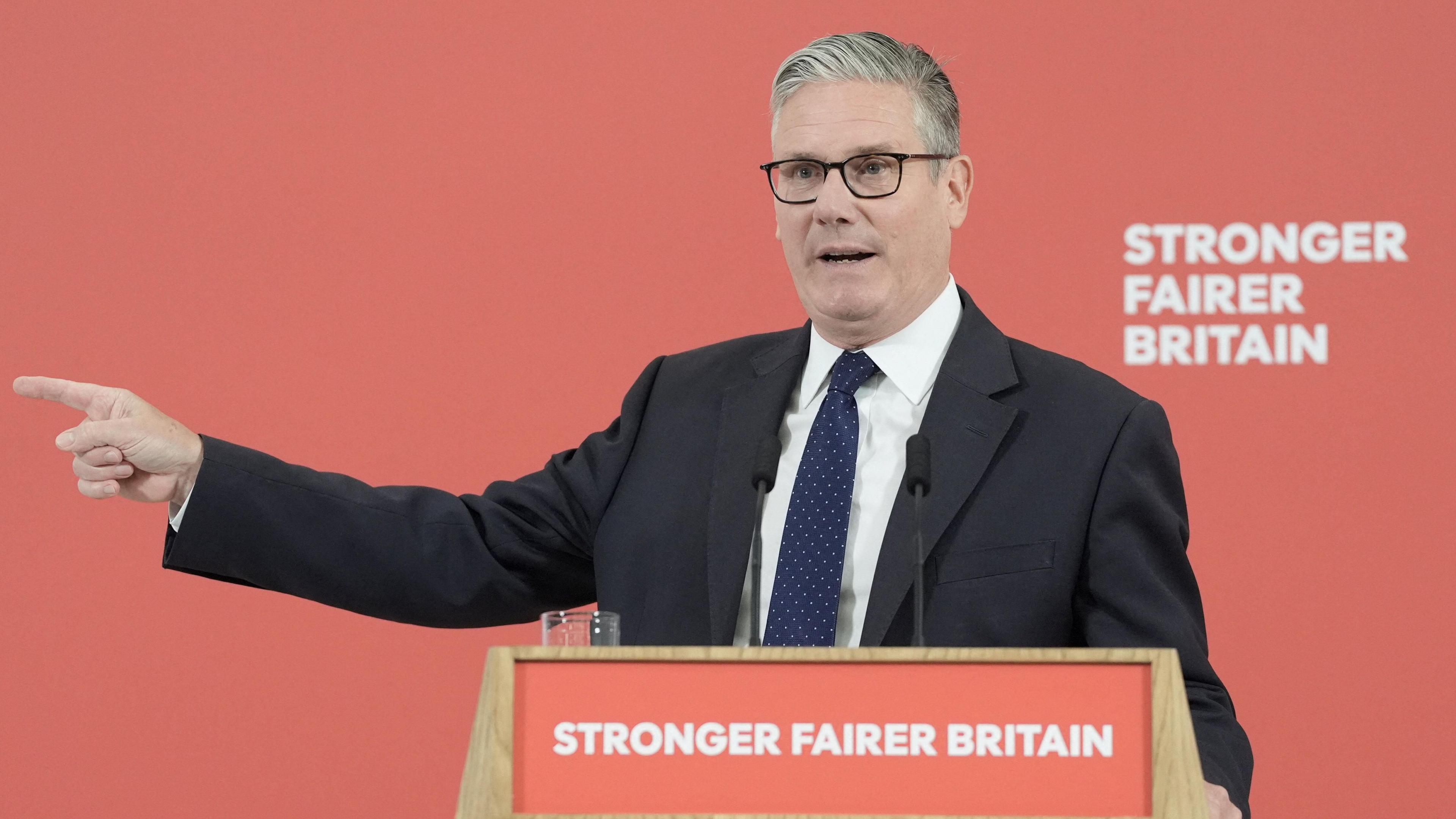 Keir Starmer speaking behind a podium reading "Stronger Fairer Britain"