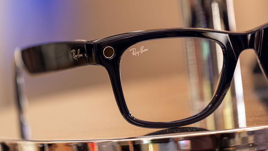 A close-up of a pair of black Meta Ray-Ban glasses on a metal display.