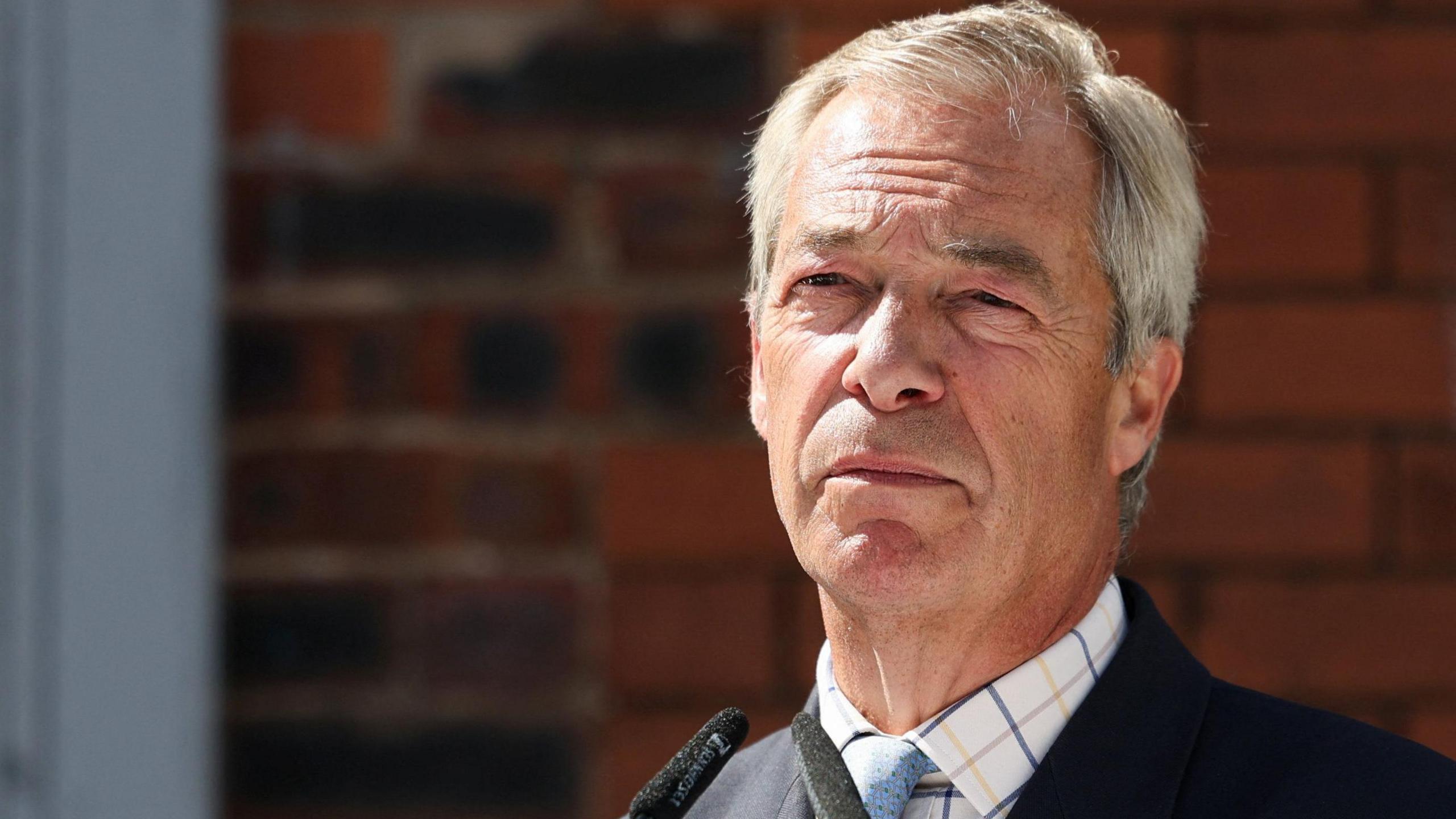 Reform UK Nigel Farage, shown wearing a dark suit and light blue tie