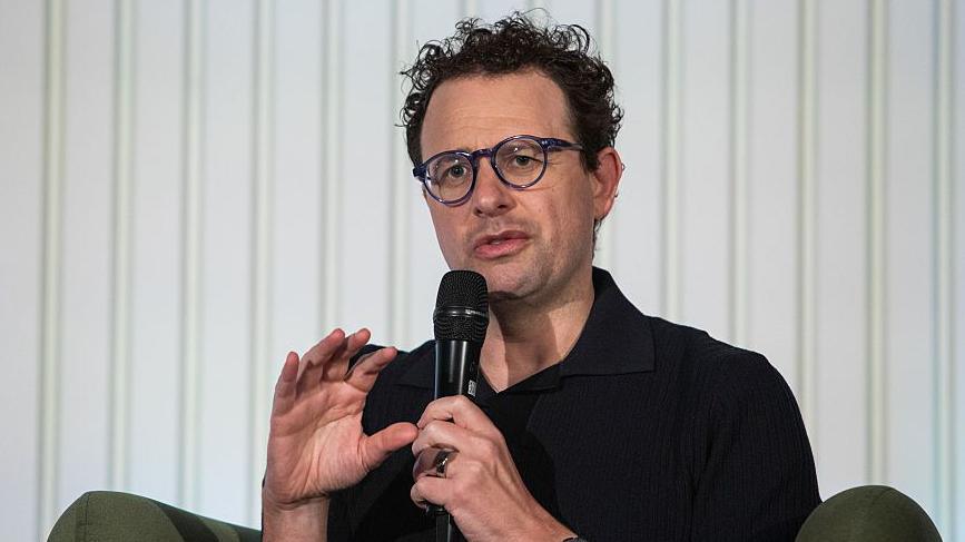 Anthropic chief executive Dario Amodei speaks through a microphone during a summit