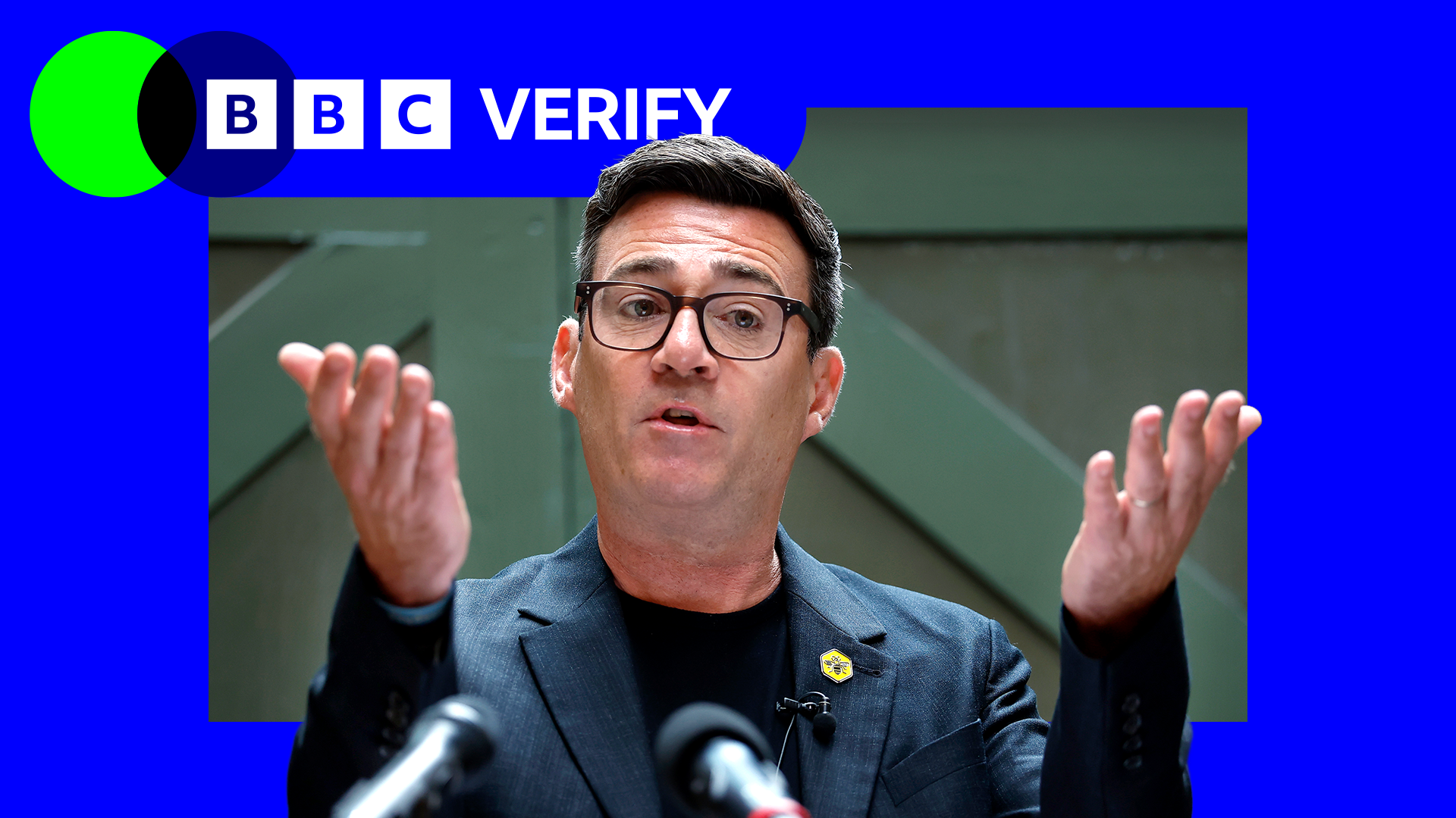 Andy Burnham holds his hands up in front of him as he delivers a speech 