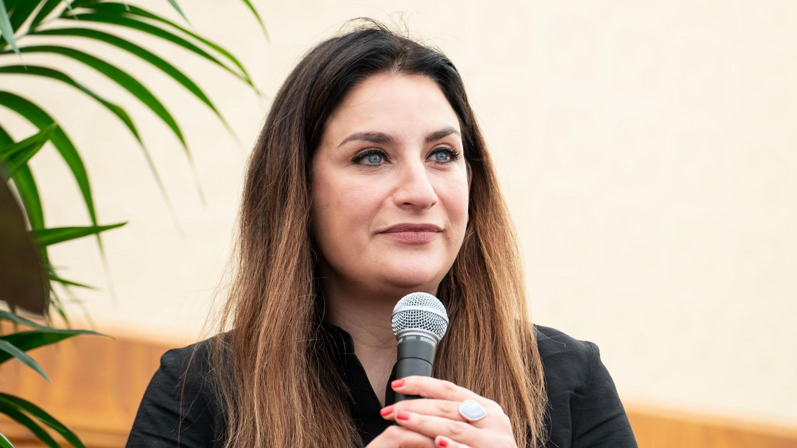 Baroness Luciana Berger speaking at the Kite Festival in 2022 sitting down and holding a microphone