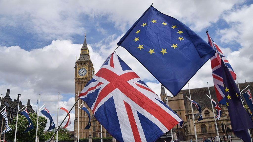 Union Jack and EU flags outside the Houses of Parliament in London.