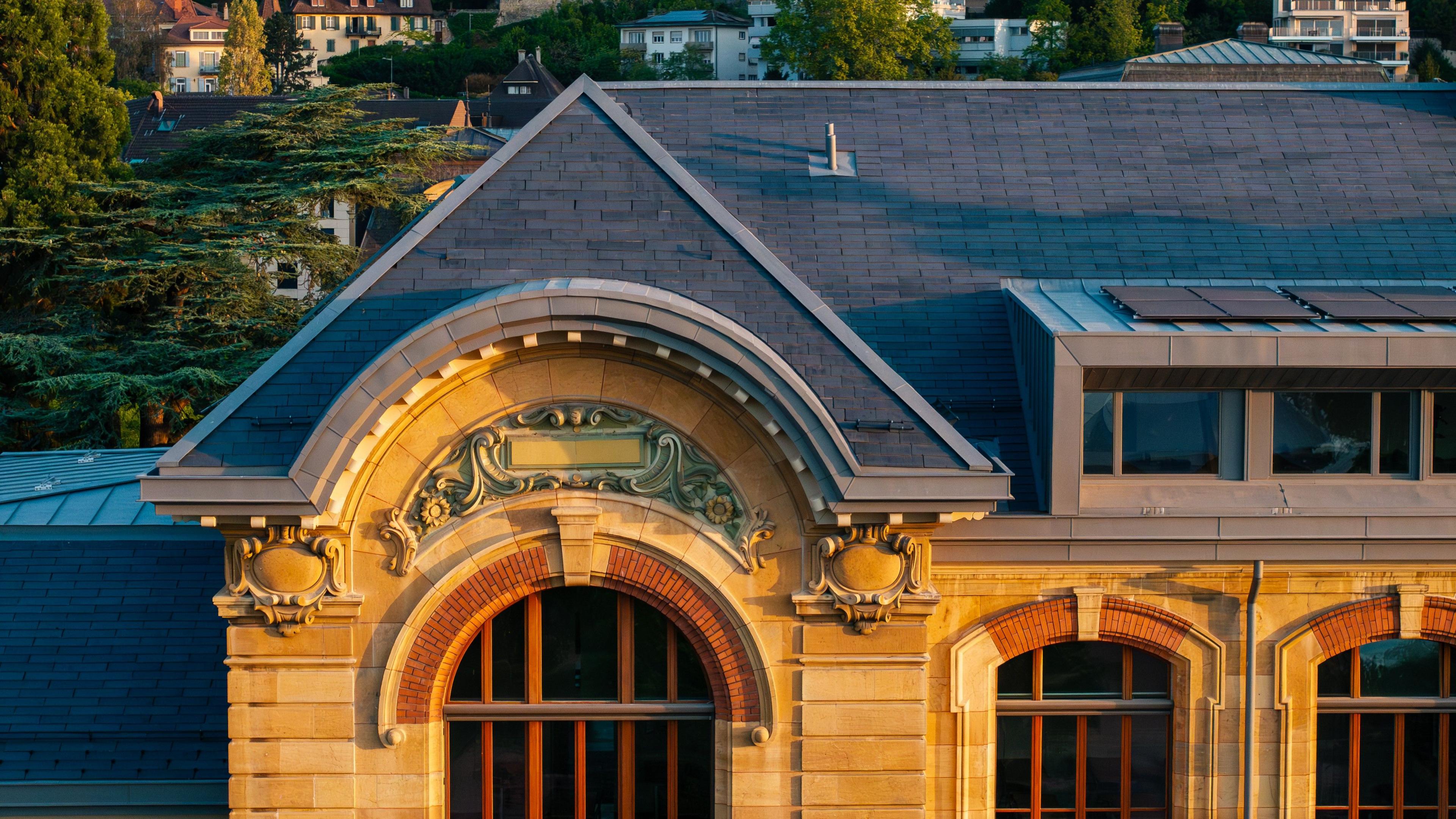 The roof of the grand Lycée Jean-Piaget in Neuchâtel, Switzerland, built in 1900. It has solar roof tiles, which look like regular tiles.
